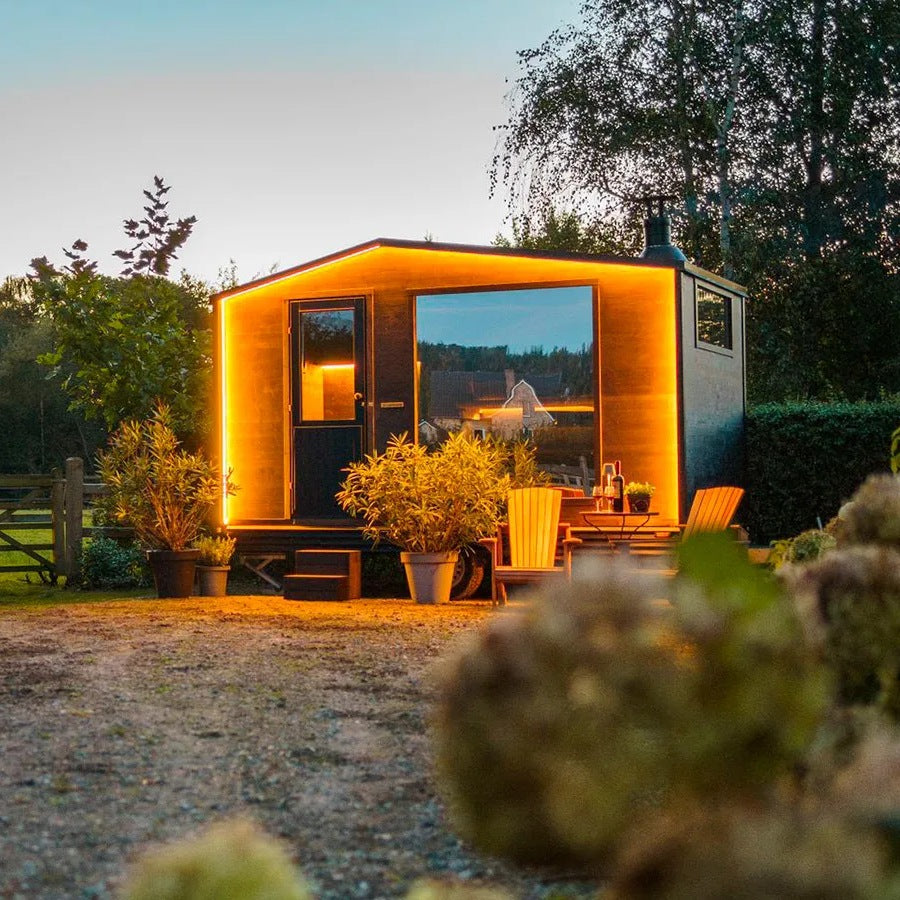 Lapelland Medium Plus i trädgården på kvällen med öppen dörr och panoramafönster