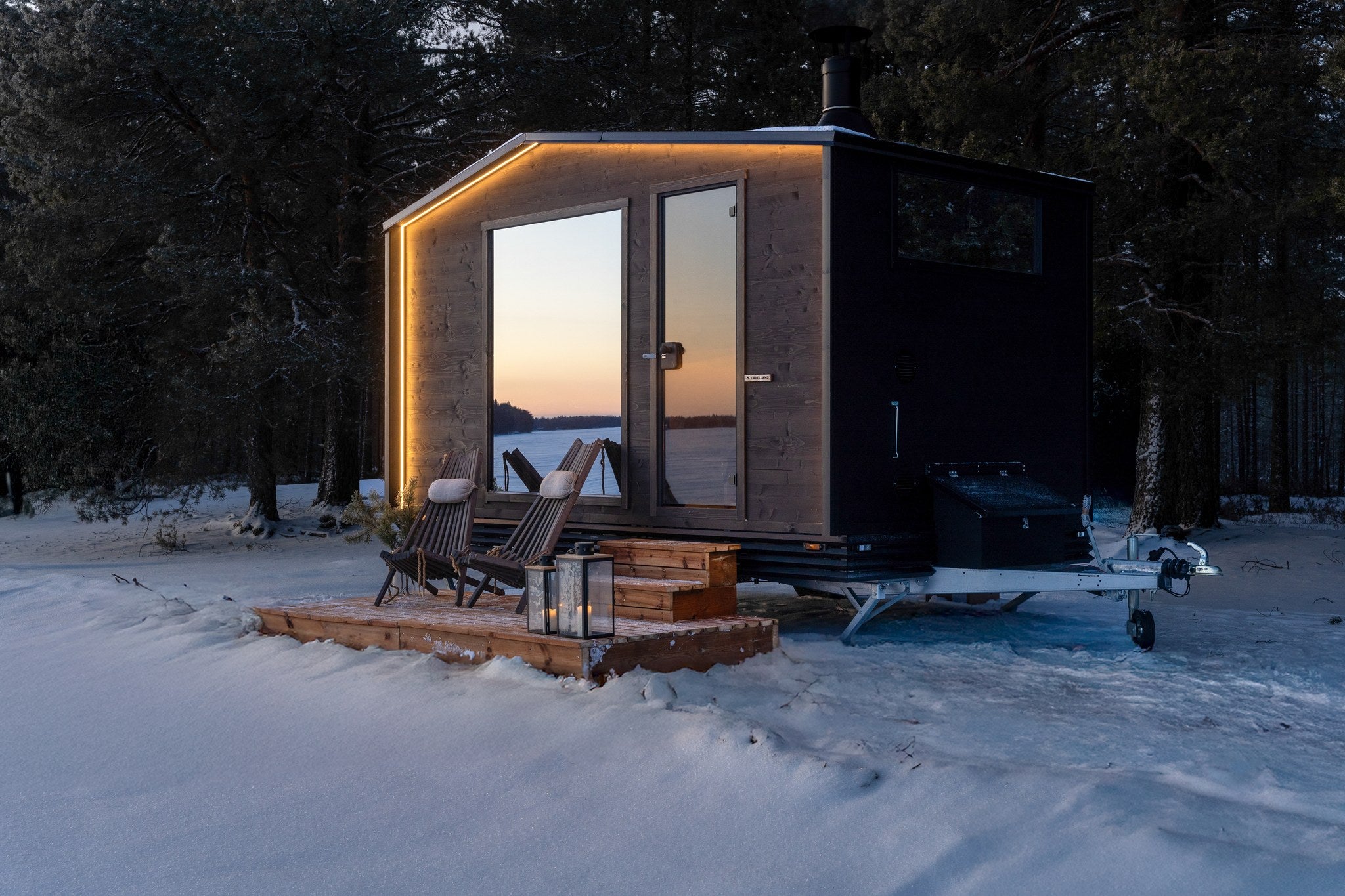 Lapelland Large bastuvagn med upplyst basturum i skymningen, altan och stolar i snön