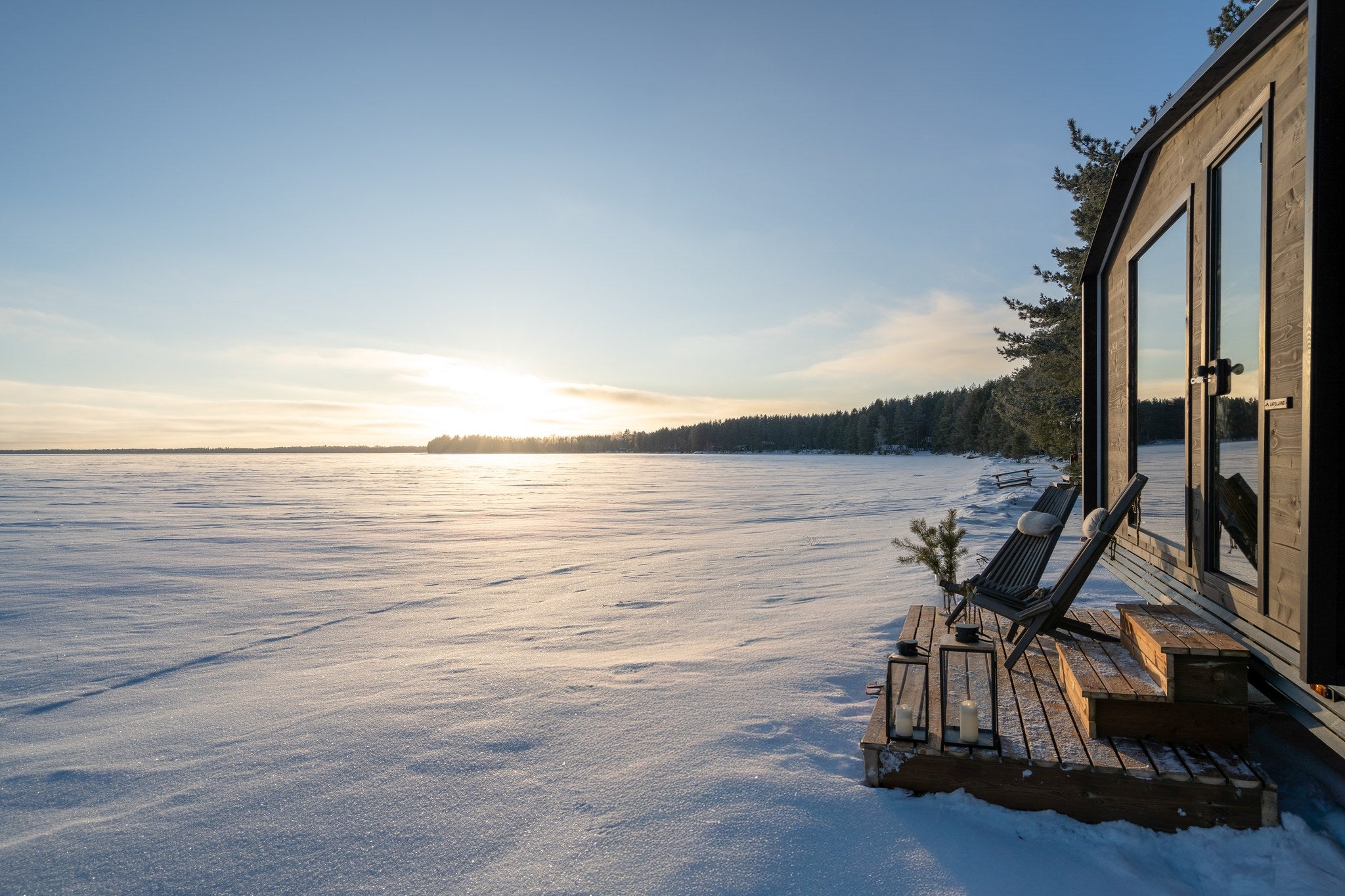 Lapelland Large bastuvagn med altan och stolar i solnedgången vid sjön
