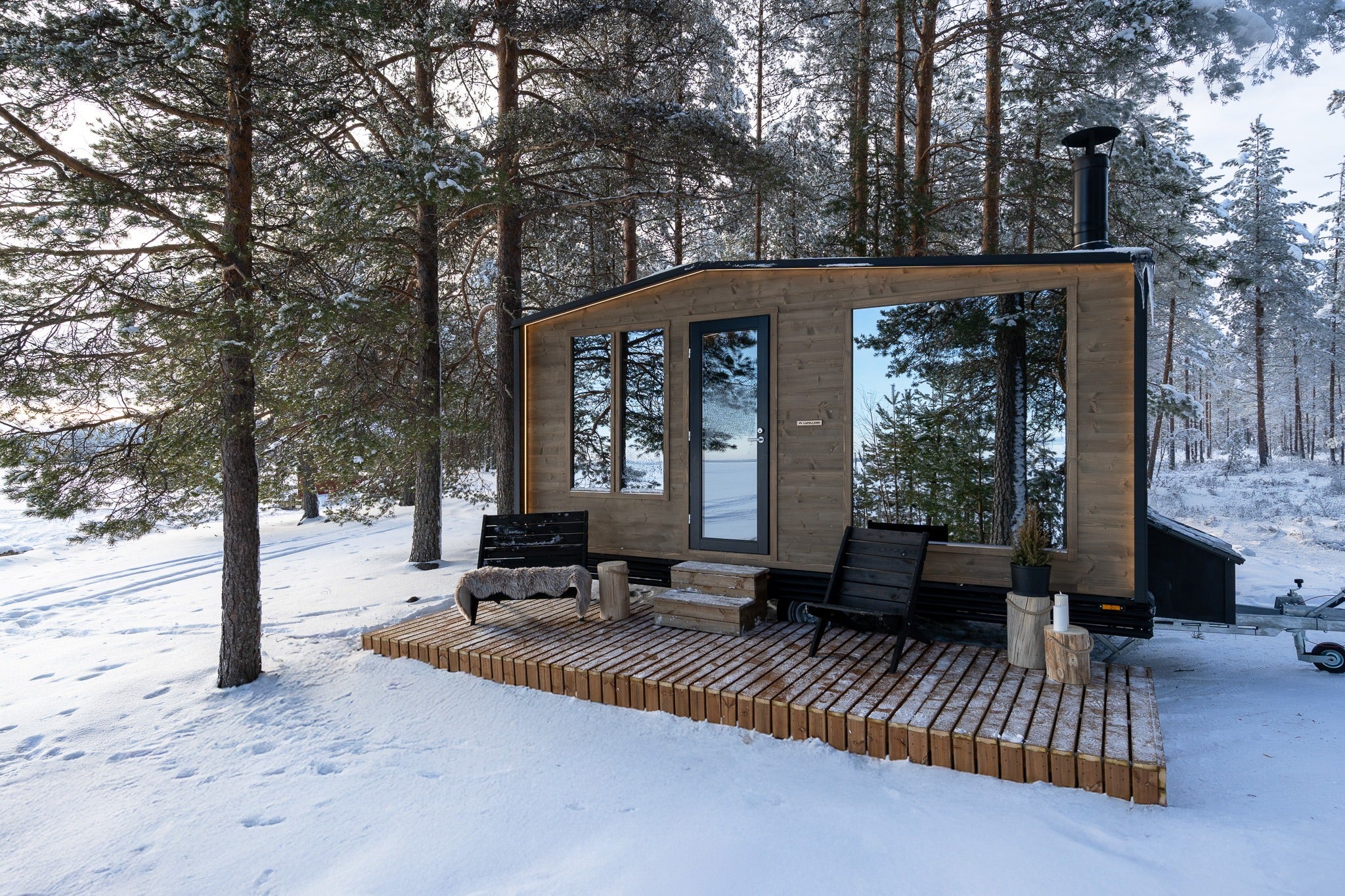 Lapelland Sauna XL bastuvagn i vinterlandskap med altan och utemöbler